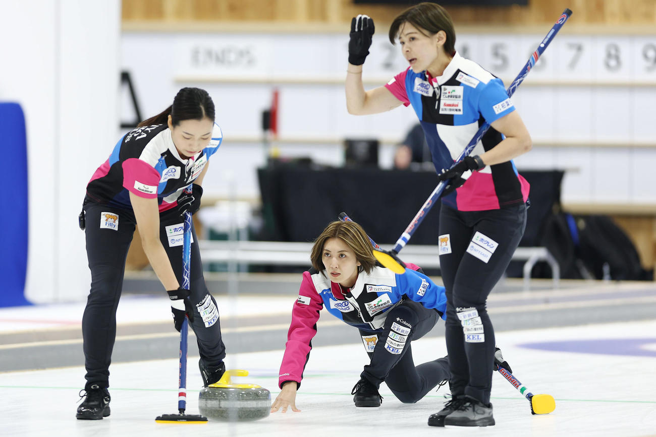 SC軽井沢クラブ対フォルティウス　第1エンド、ストーンを投じるフォルティウス吉村。左は近江谷、右は小野寺（撮影・前田充）