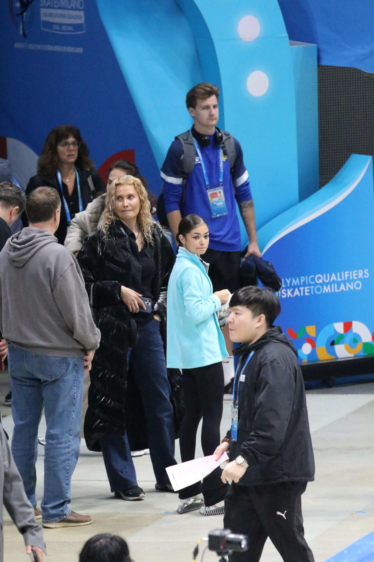 ミラノ・コルティナ冬季五輪最終予選の公式練習前、エテリ・トゥトベリゼ・コーチ（右から4人目）と待つアデリア・ペトロシャン（同3人目）（撮影・松本航）