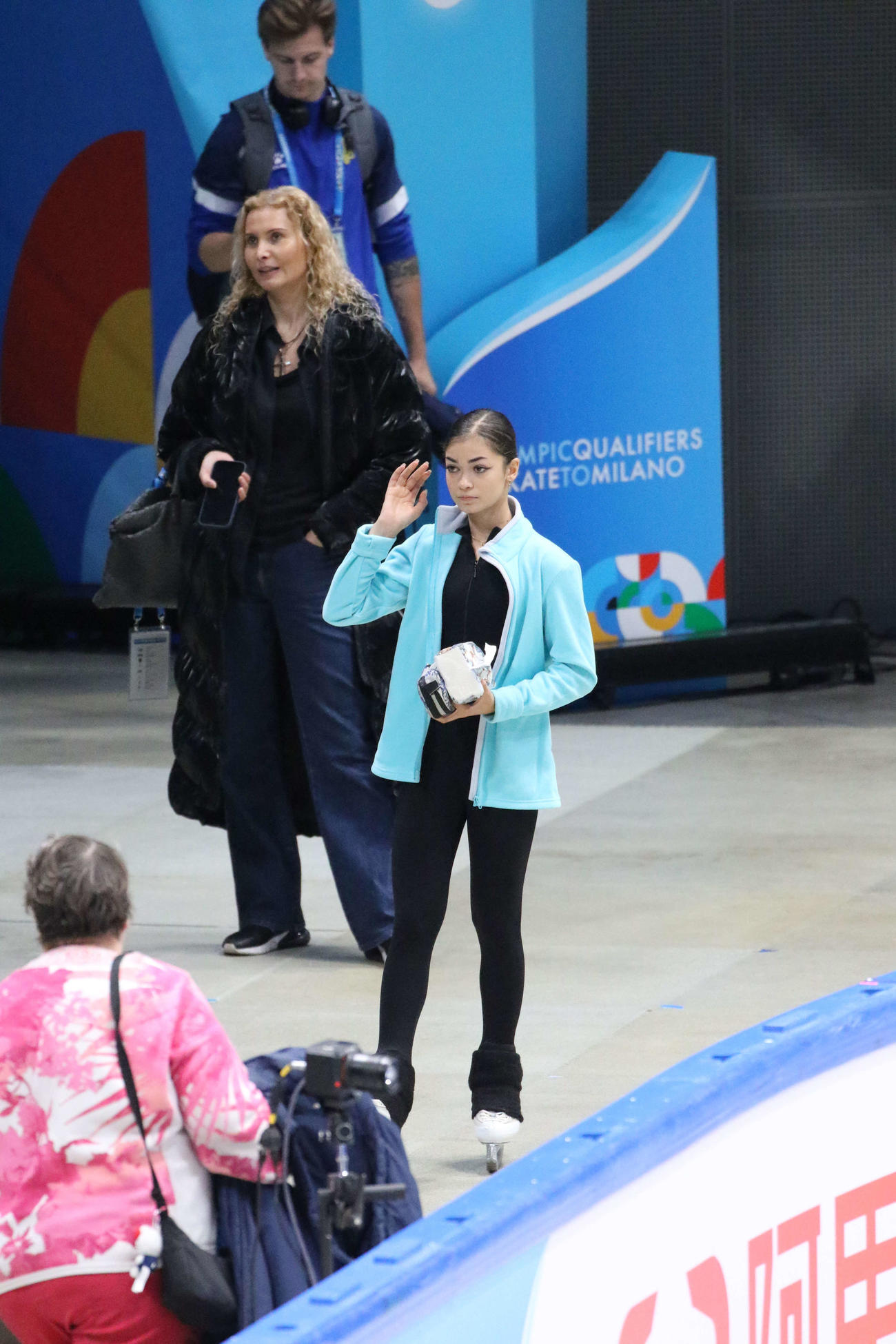 ミラノ・コルティナ冬季五輪最終予選の公式練習前、エテリ・トゥトベリゼ・コーチ（右から2人目）と待つアデリア・ペトロシャン（右）（撮影・松本航）