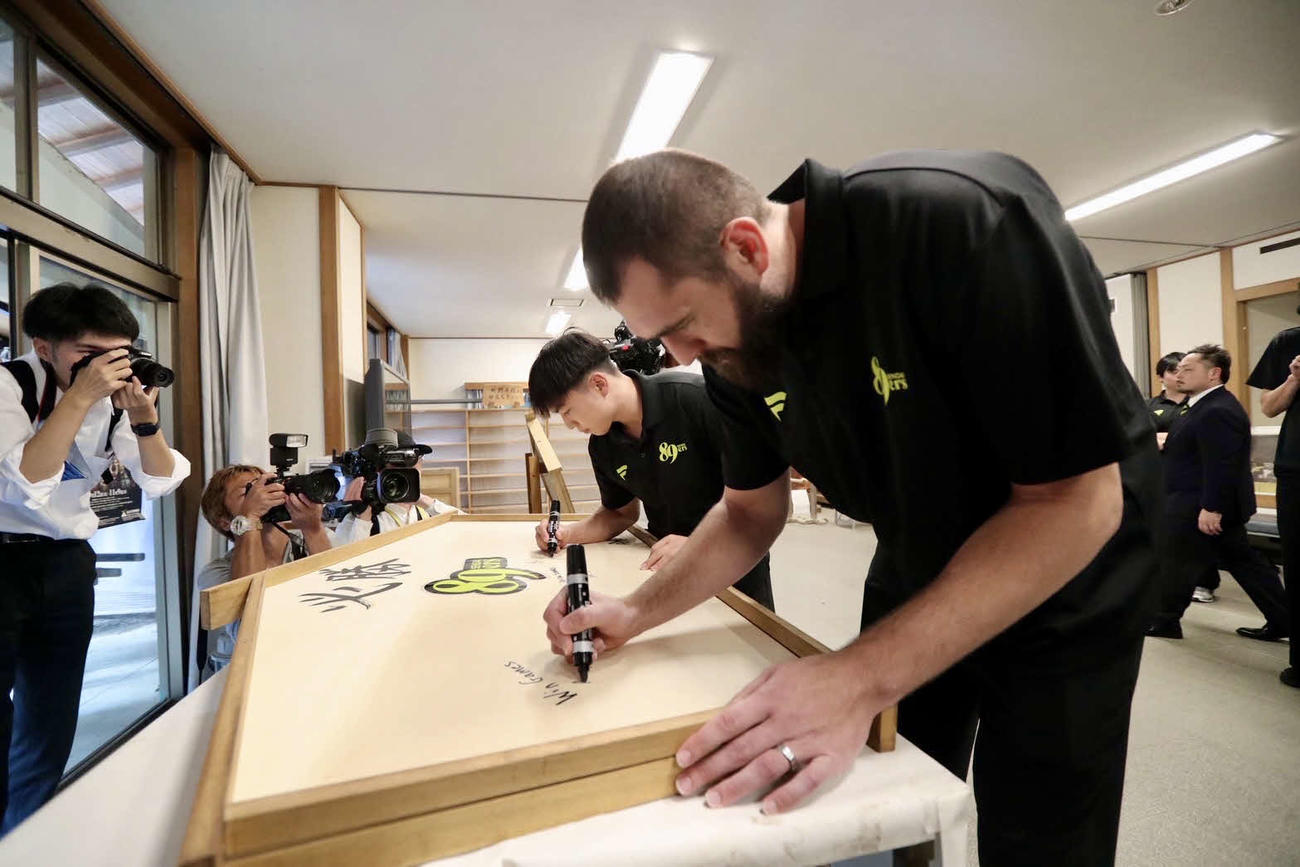 特大絵馬に今季の目標を記す、キャプテンのB1仙台渡辺（奥）とブース（撮影・高橋香奈）