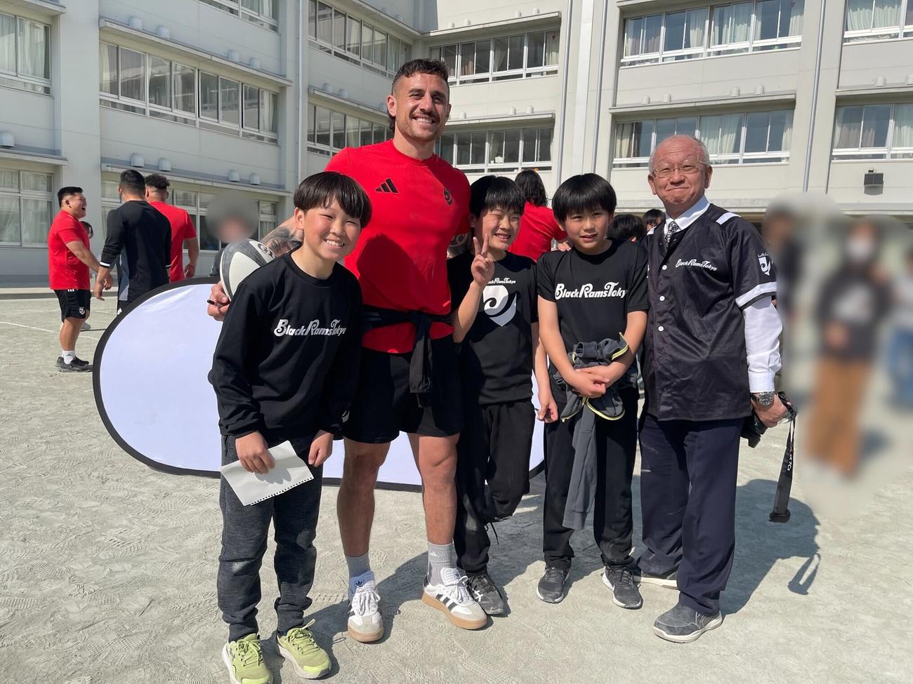 昨季、地域の学校のグラウンドで試合前日練習を行い、笑顔を見せるBR東京のTJ・ペレナラ（左から2人目）ら（一部加工、リコーブラックラムズ東京提供）