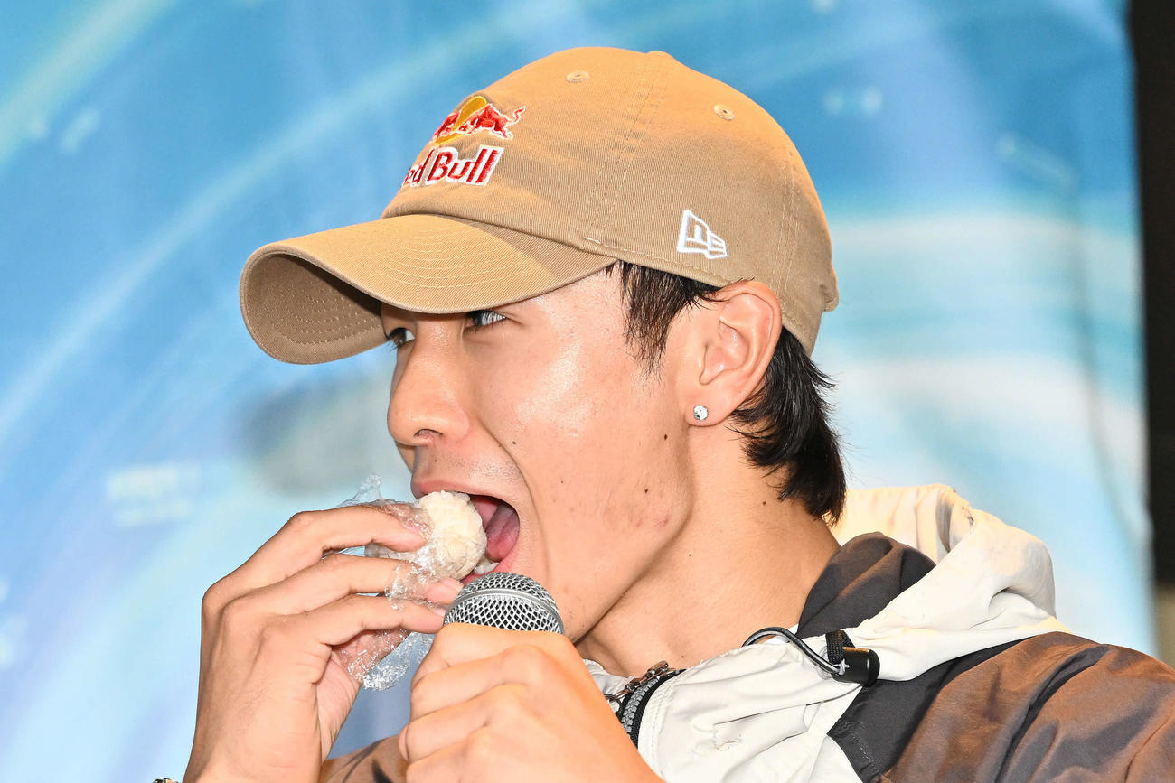トークセッションで小分けだし入りおにぎり「パワーボール」を食べるShigekix（撮影・滝沢徹郎）