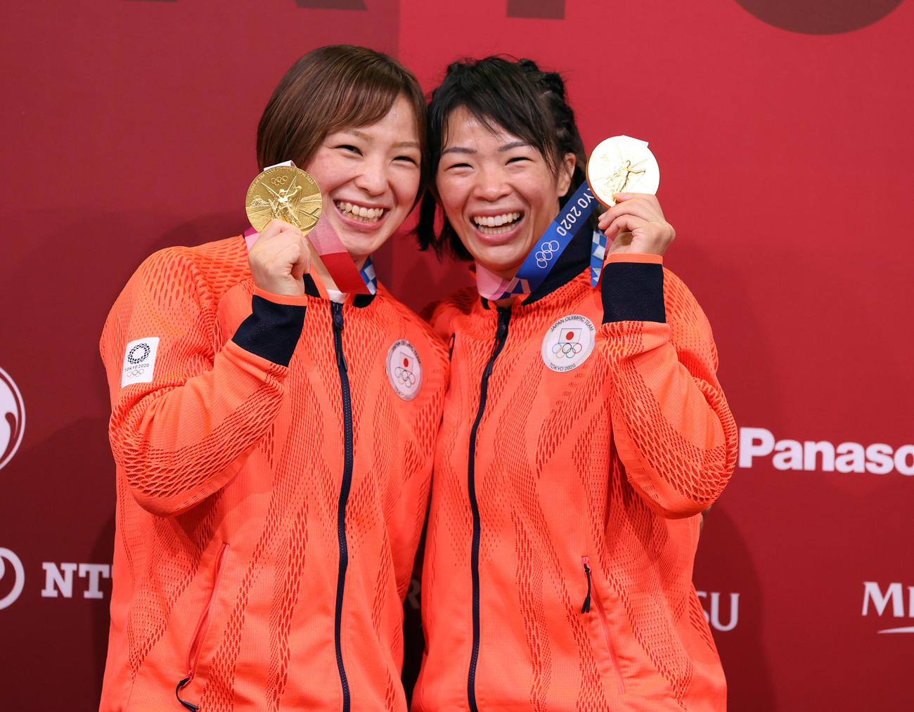 女子57キロ級決勝で金メダルを獲得した川井梨（右）は、62キロ級で金メダルの妹友香子と笑顔を見せる（2021年8月5日撮影）