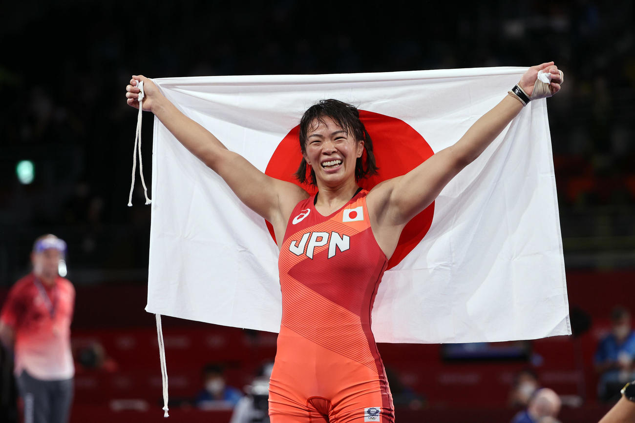 女子57キロ級で金メダルの川井梨紗子は日の丸を手に笑顔（2021年8月5日撮影）