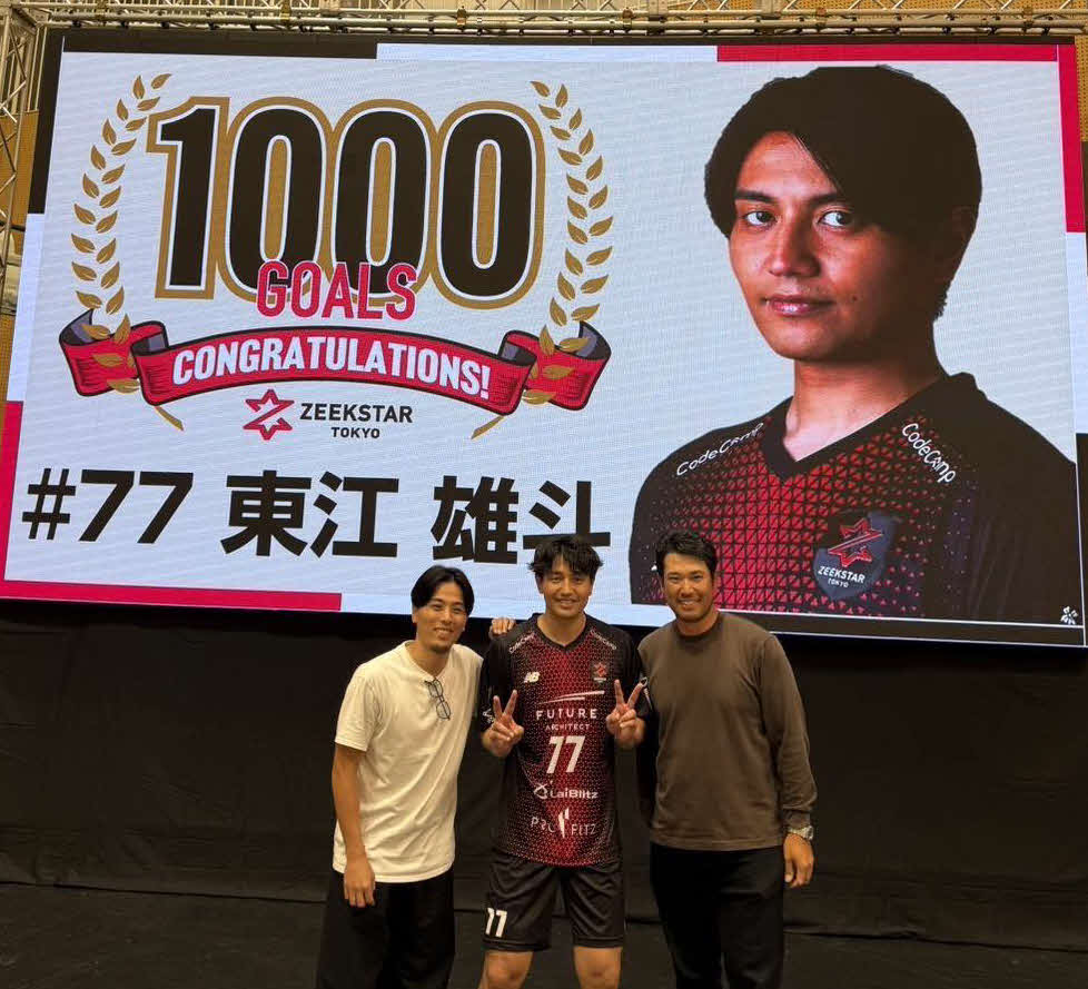 通算1000得点を達成したジークスター東京の東江（中）と記録を祝福するビジョンの前で記念撮影する松山英樹（右）と富樫勇樹