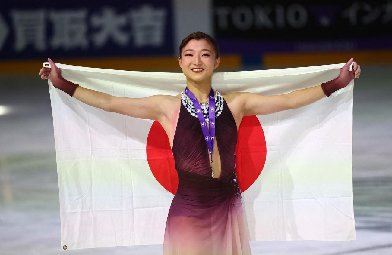 GPシリーズ第1戦フランス大会で2位となり、日の丸を背に笑顔でポーズを決める坂本花織（ロイター）