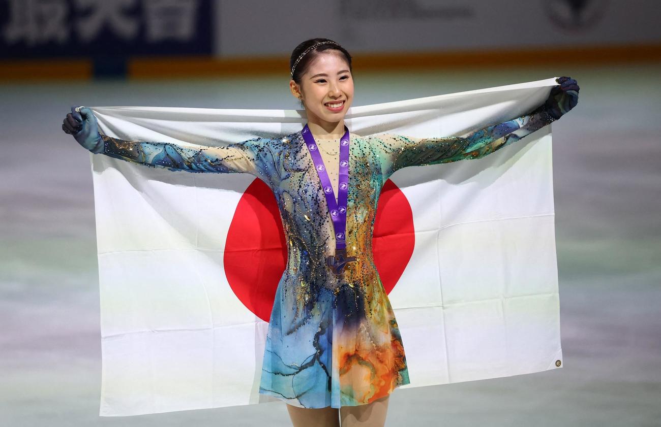 GPシリーズ第1戦フランス大会で3位となり、日の丸を背に笑顔でポーズを決める住吉りをん（ロイター）