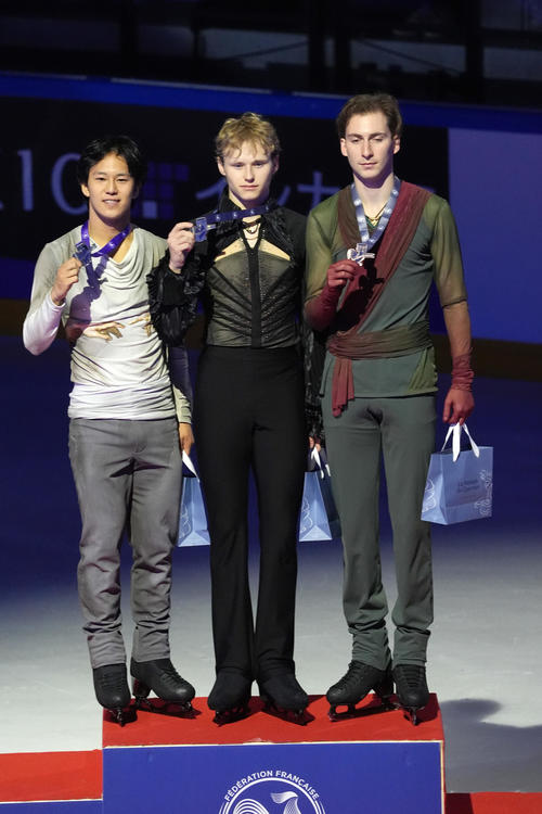 男子シングル表彰式　優勝したイリア・マリニン（中央）。左は2位のアダム・シャオイムファ、右は3位のニカ・エガゼ（撮影・パオロ　ヌッチ）