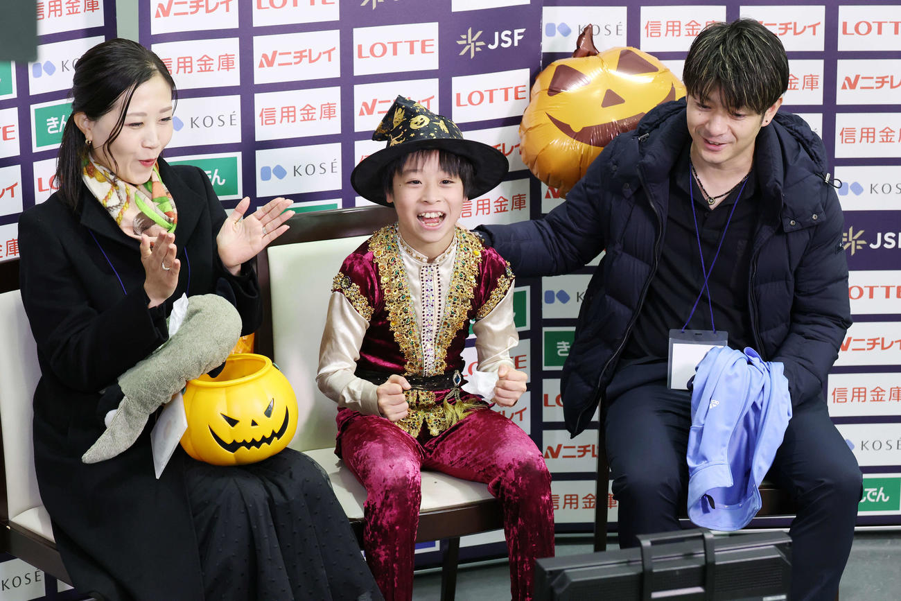 全日本ノービス選手権ノービスA男子で得点が発表されガッツポーズする日高晴久。左は南雲百恵コーチ、右は中田誠人コーチ（撮影・宮地輝）