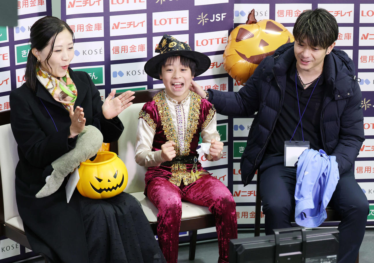 全日本ノービス選手権ノービスA男子で得点が発表されガッツポーズする日高晴久。左は南雲百恵コーチ、右は中田誠人コーチ（撮影・宮地輝）