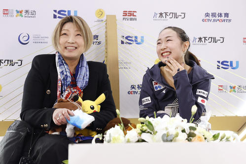 女子SPの得点を確認し、笑顔の松生理乃。左は本郷裕子コーチ＝重慶（共同）