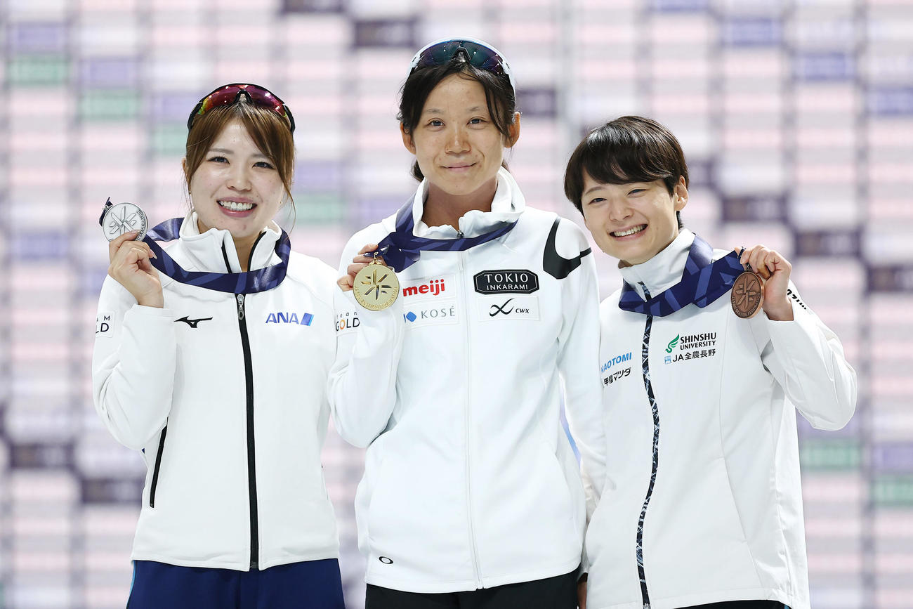 女子1500メートルで優勝し、メダルを手に笑顔を見せる高木（中央）。左は2位の佐藤、右は3位の飯田（撮影・前田充）