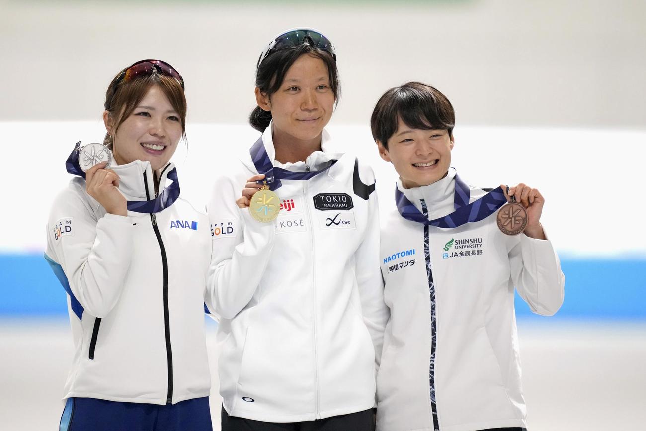 女子1500メートルで10連覇を果たし表彰式で笑顔を見せる高木美帆（中央）。左は2位の佐藤綾乃。右は3位の山田梨央（共同）