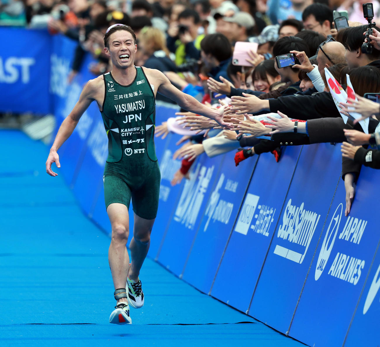 観客とタッチしながら優勝のゴールに向かう三井住友海上・安松（撮影・野上伸悟）
