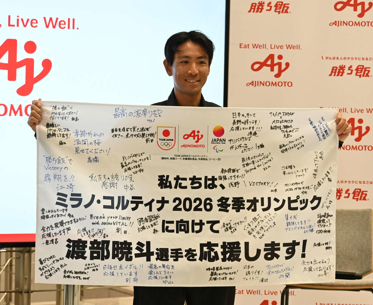味の素社員から横断幕を受け取り笑顔を見せる渡部暁斗（撮影・飯岡大暉）