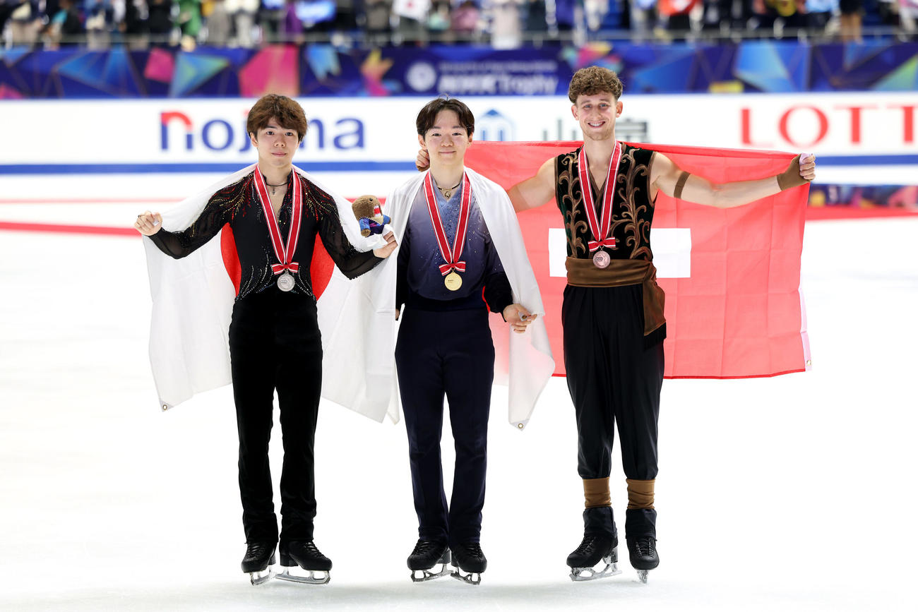 笑顔で写真に納まる優勝の鍵山（中央）。左は2位佐藤、右は3位ルーカス・ブリッチギー（撮影・前田充）