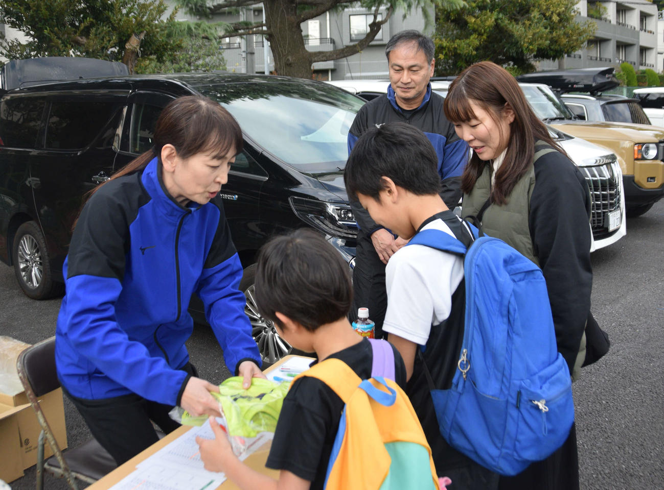 受付係をする母の橋岡直美さん（中央左）と見守る父利行さん（右奥）（撮影・泉光太郎）