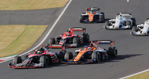 スーパーフォーミュラ最終戦、ポールポジションの岩佐歩夢（左）を先頭に1コーナーに向かう各マシン。右は2位の佐藤蓮（撮影・宮崎幸一）