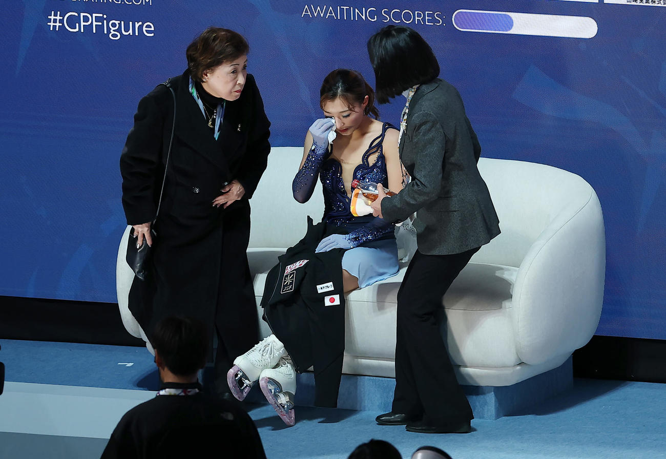 女子SPの演技を終え、キス・アンド・クライで涙をぬぐう坂本。左は中野コーチ（撮影・前田充）