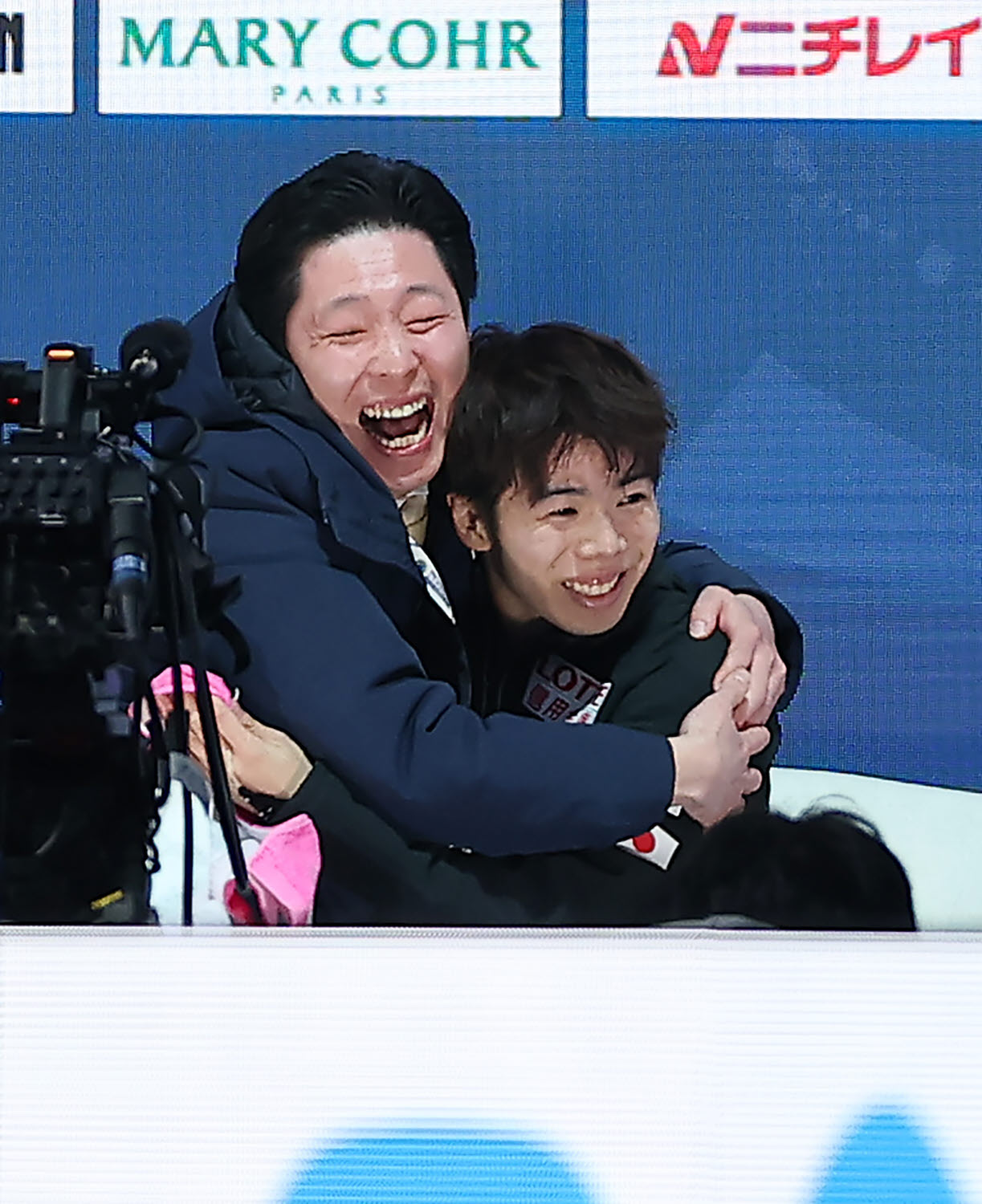 得点を確認し、日下コーチ（左）と抱き合って喜ぶ佐藤（撮影・前田充）