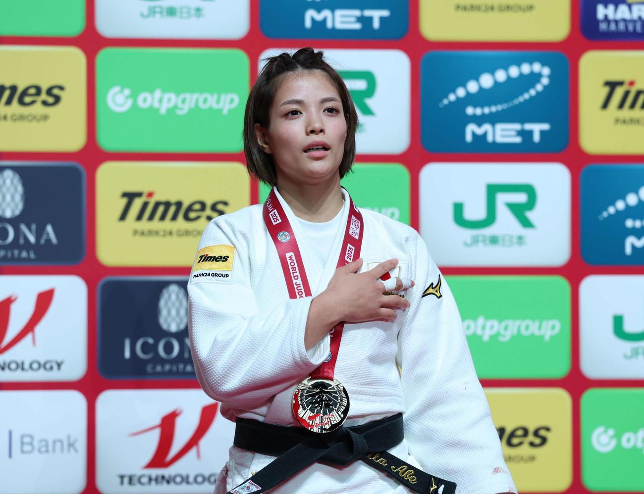 女子52キロ級決勝で優勝し金メダルを胸に君が代を歌う阿部（2025年12月6日撮影）