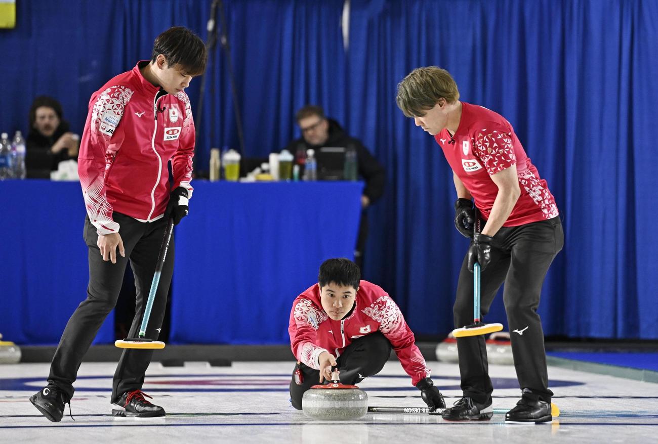 男子1次L　ポーランド戦の第3エンド、ショットを放つ臼井。左は柳沢、右は小泉（共同）