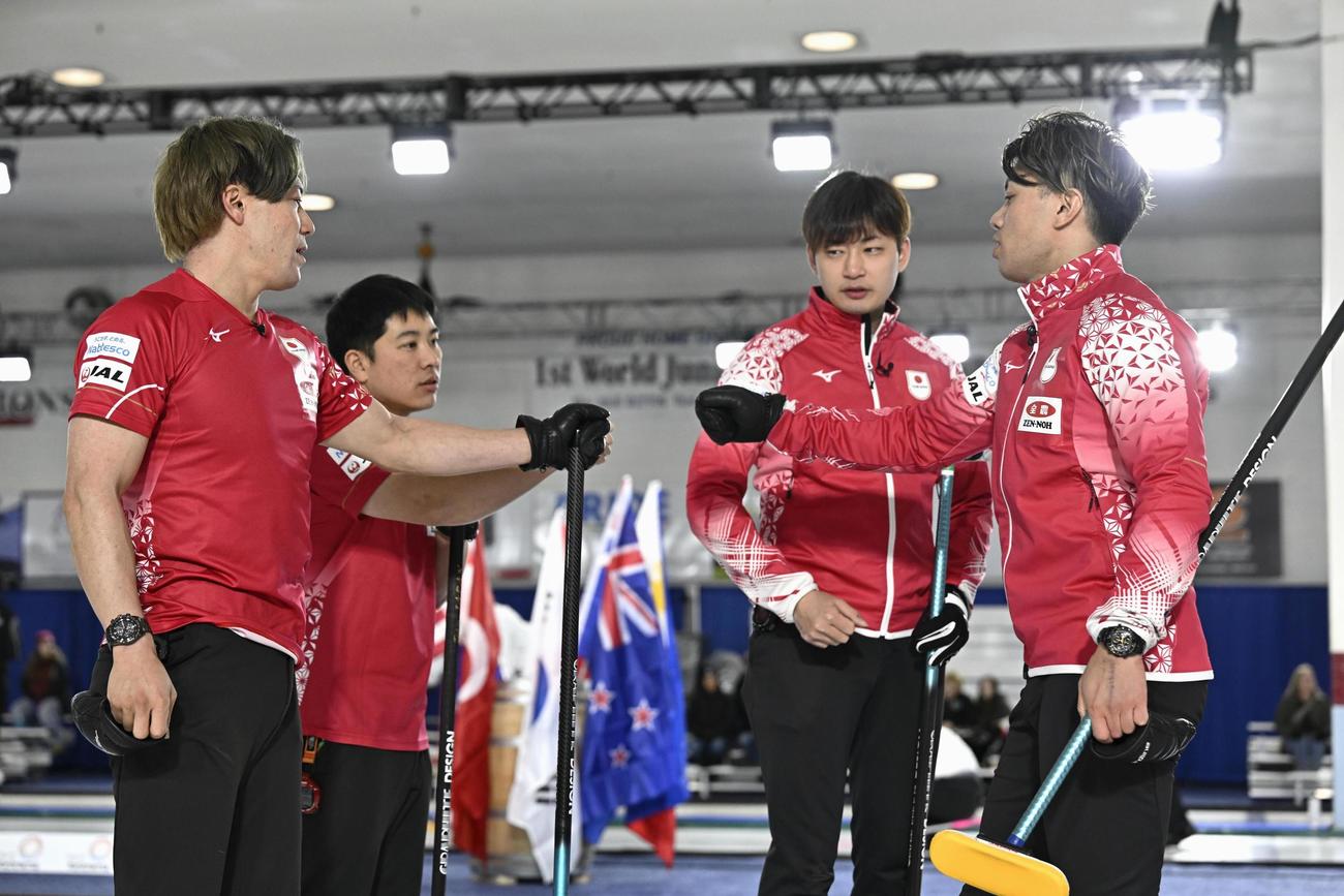 男子1次L　ポーランド戦の第7エンドを終え、タッチを交わす（左から）小泉、臼井、柳沢、山口（共同）