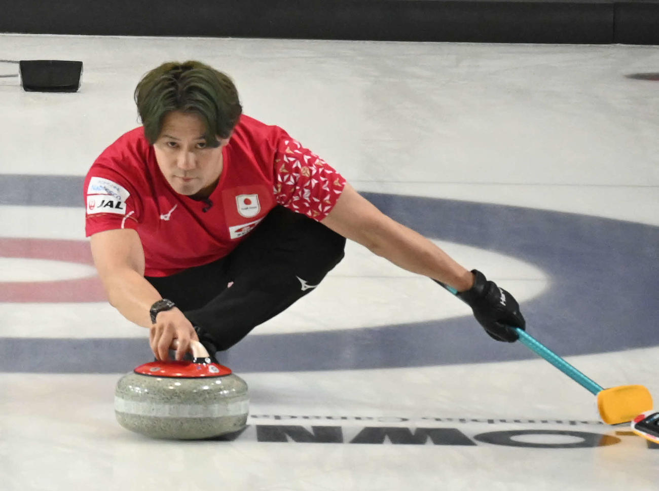 ストーンを投げる男子日本代表のリード小泉（撮影・飯岡大暉）