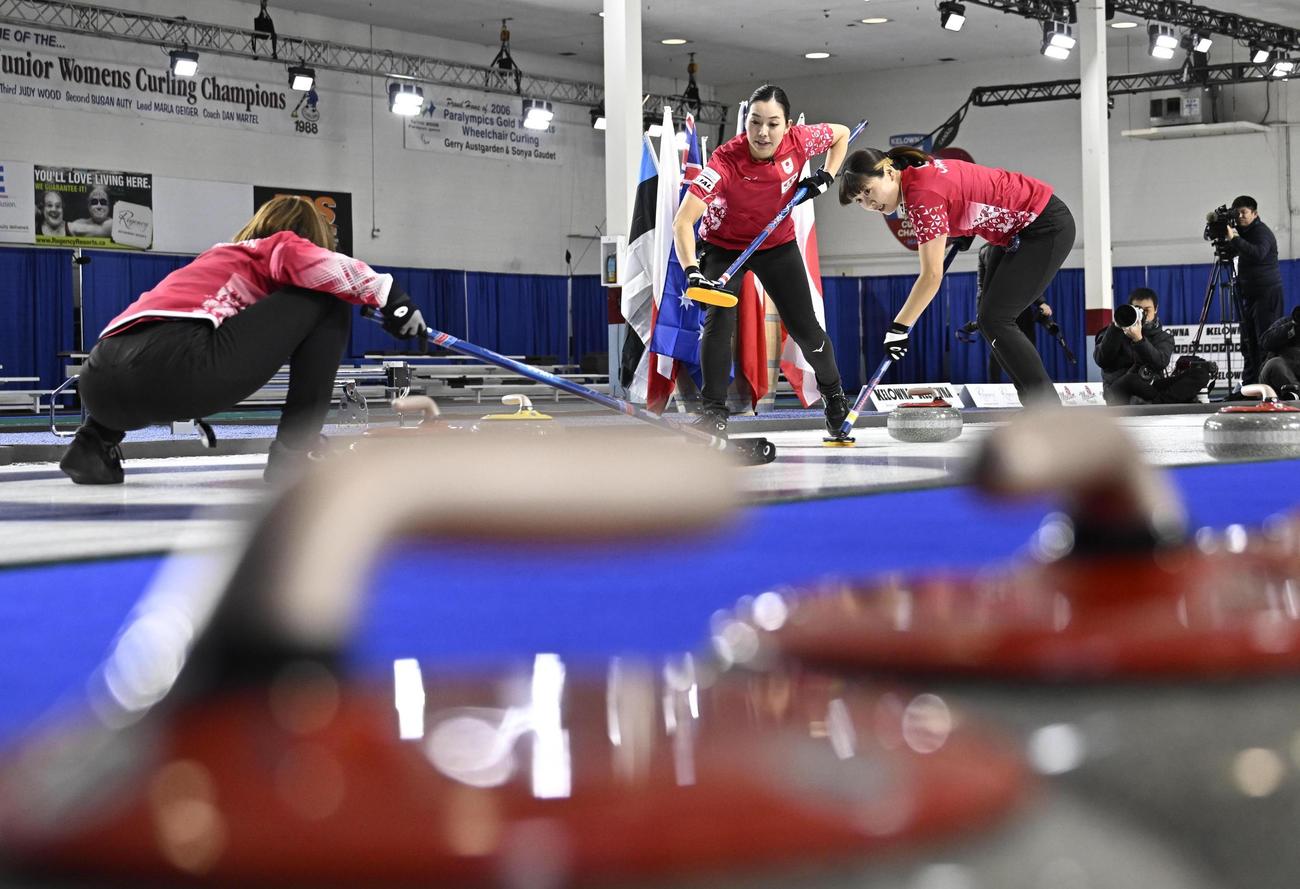 女子プレーオフ　ノルウェー戦の第2エンド、スイープする小谷（右）と近江谷。左は吉村＝ケロウナ（共同）