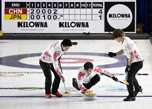 男子プレーオフ　中国戦の第6エンド、ショットを放つ柳沢。左は山本、右は小泉＝ケロウナ（共同）