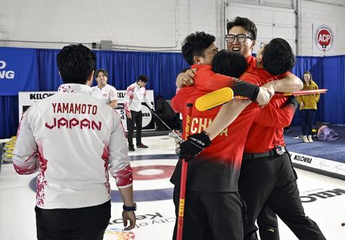 男子プレーオフで日本を破って五輪出場権を獲得し、歓喜する中国選手（右）＝ケロウナ（共同）