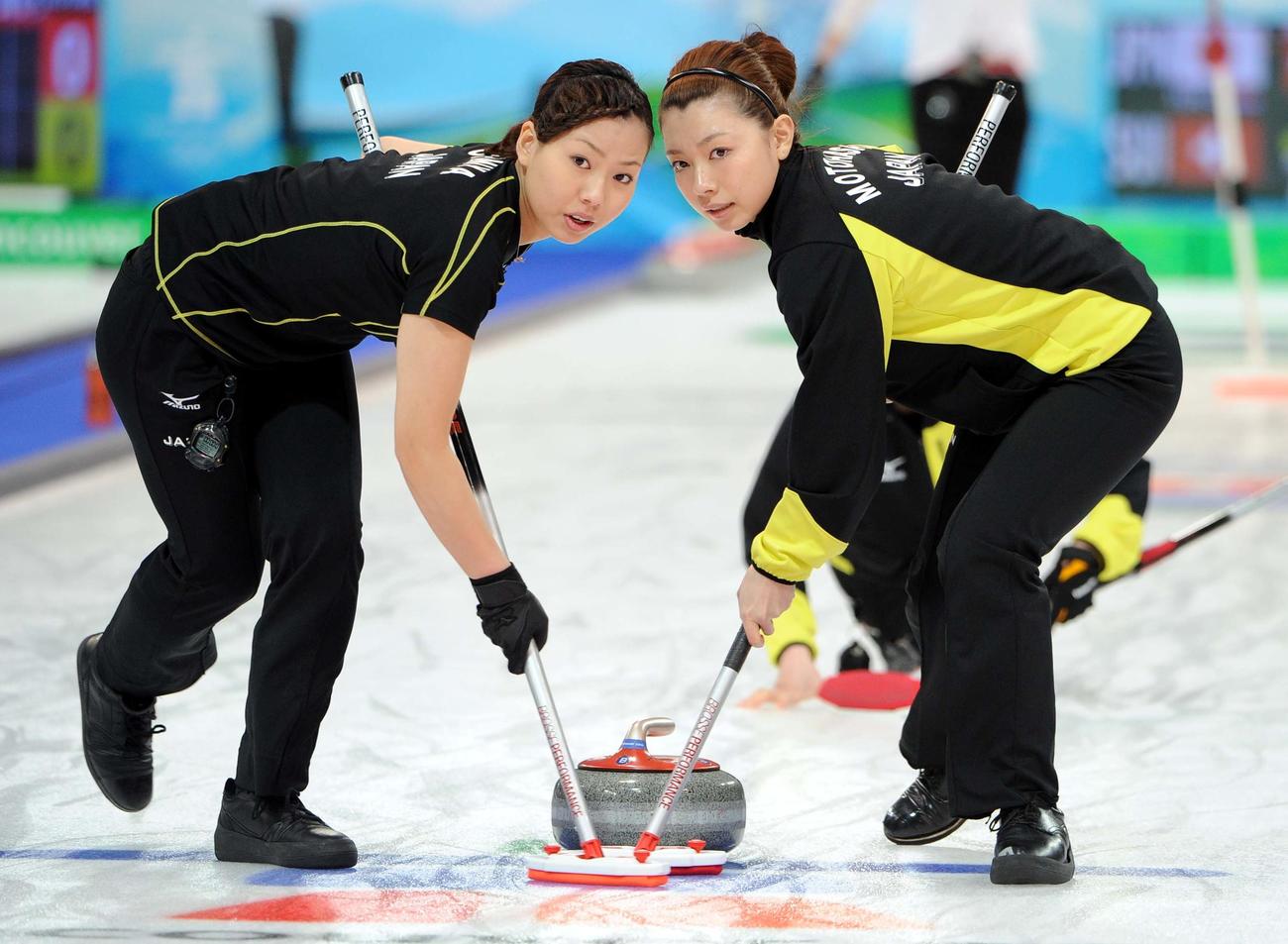 2010年2月、バンクーバー五輪カーリング女子1次リーグのスイス戦で、ストーンをスイープする本橋（右）と近江谷