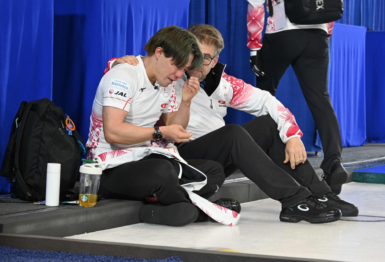 五輪出場を逃しアーセル・コーチ（右）に声をかけられ涙する男子日本代表の小泉（撮影・飯岡大暉）