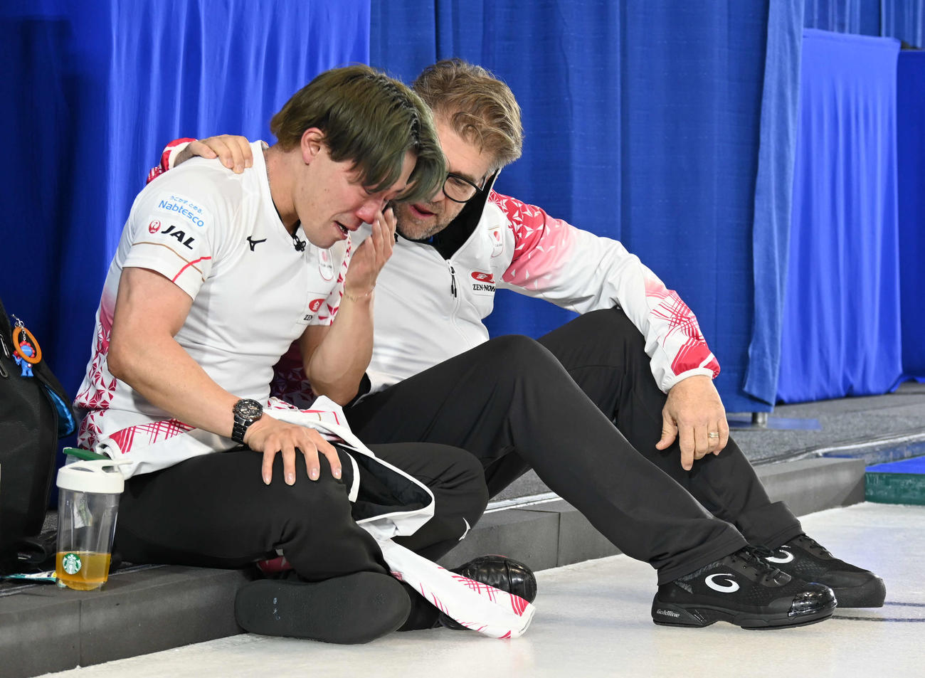 五輪出場を逃しアーセル・コーチ（右）に声をかけられ涙する男子日本代表の小泉（撮影・飯岡大暉）