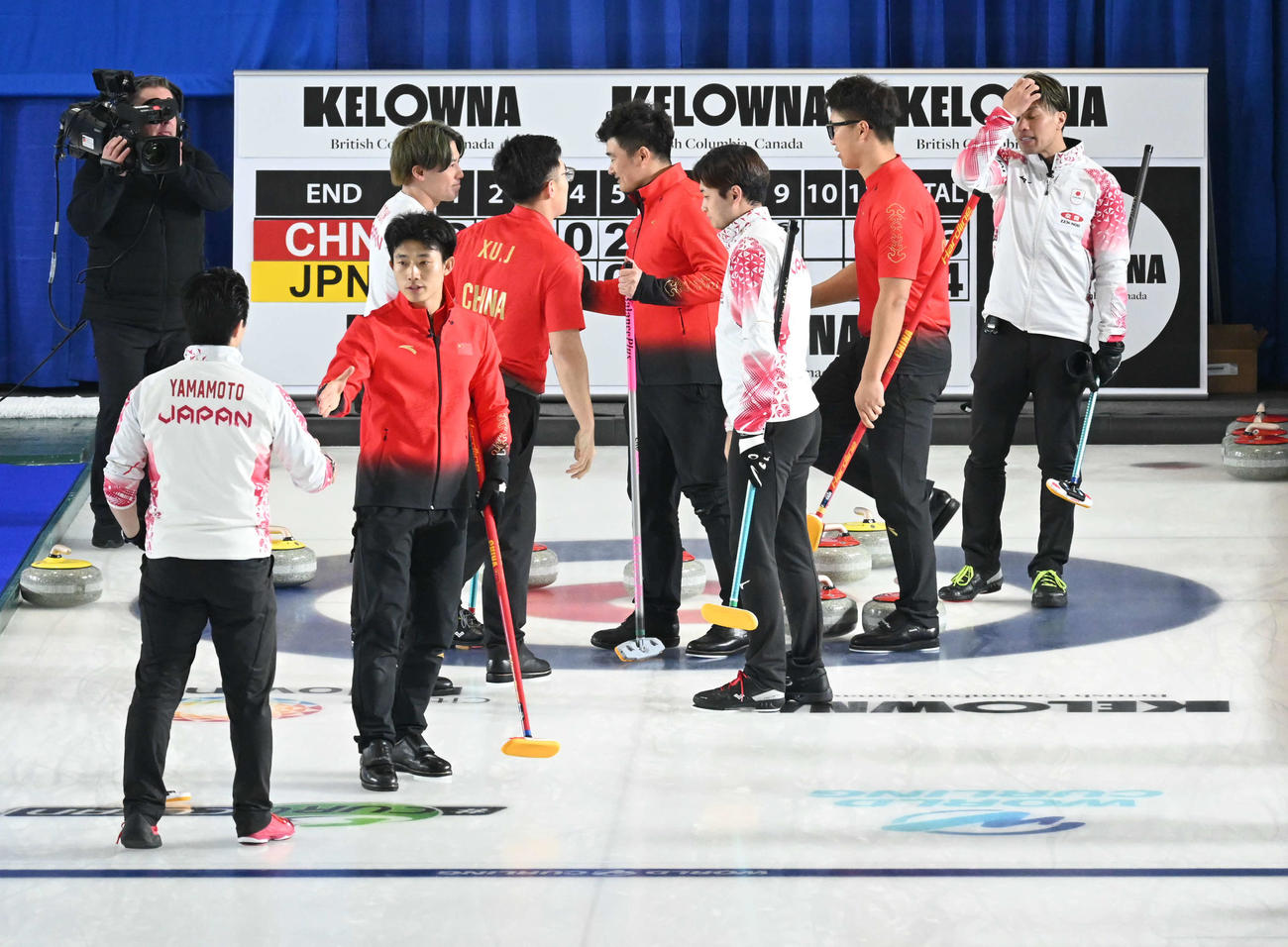 第9エンド、負けを認めて握手する男子日本代表（撮影・飯岡大暉）