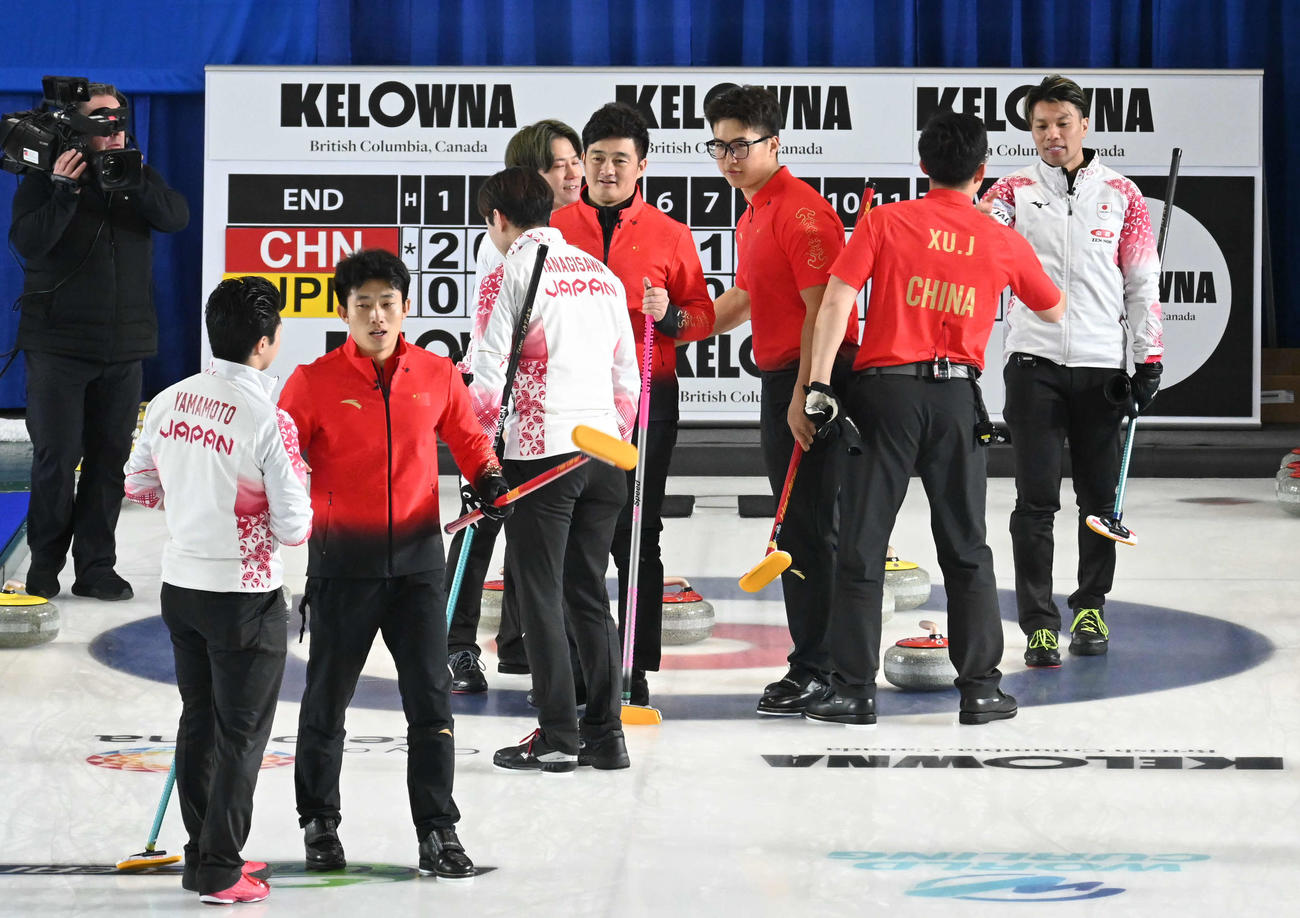 第9エンド、負けを認めて握手する男子日本代表（撮影・飯岡大暉）