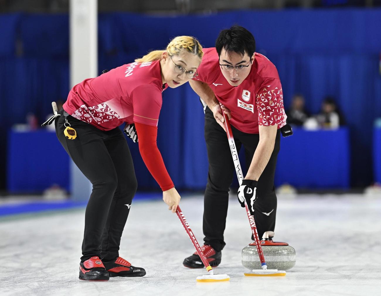 混合ダブルス1次L　韓国戦の第3エンド、スイープする小穴桃里（左）、青木豪（共同）