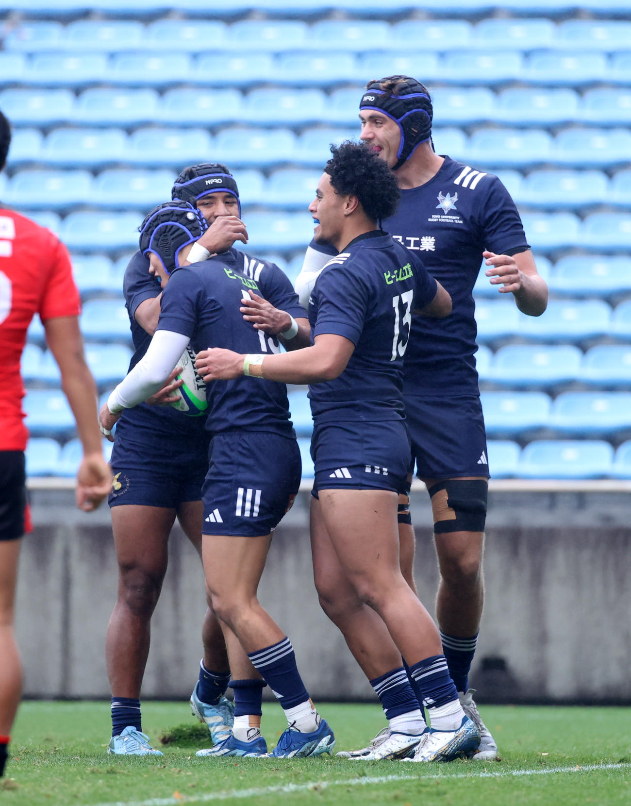 帝京大対東洋大　前半、東洋大・池渕（右から3人目）はトライを決め喜び合う（撮影・柴田隆二）