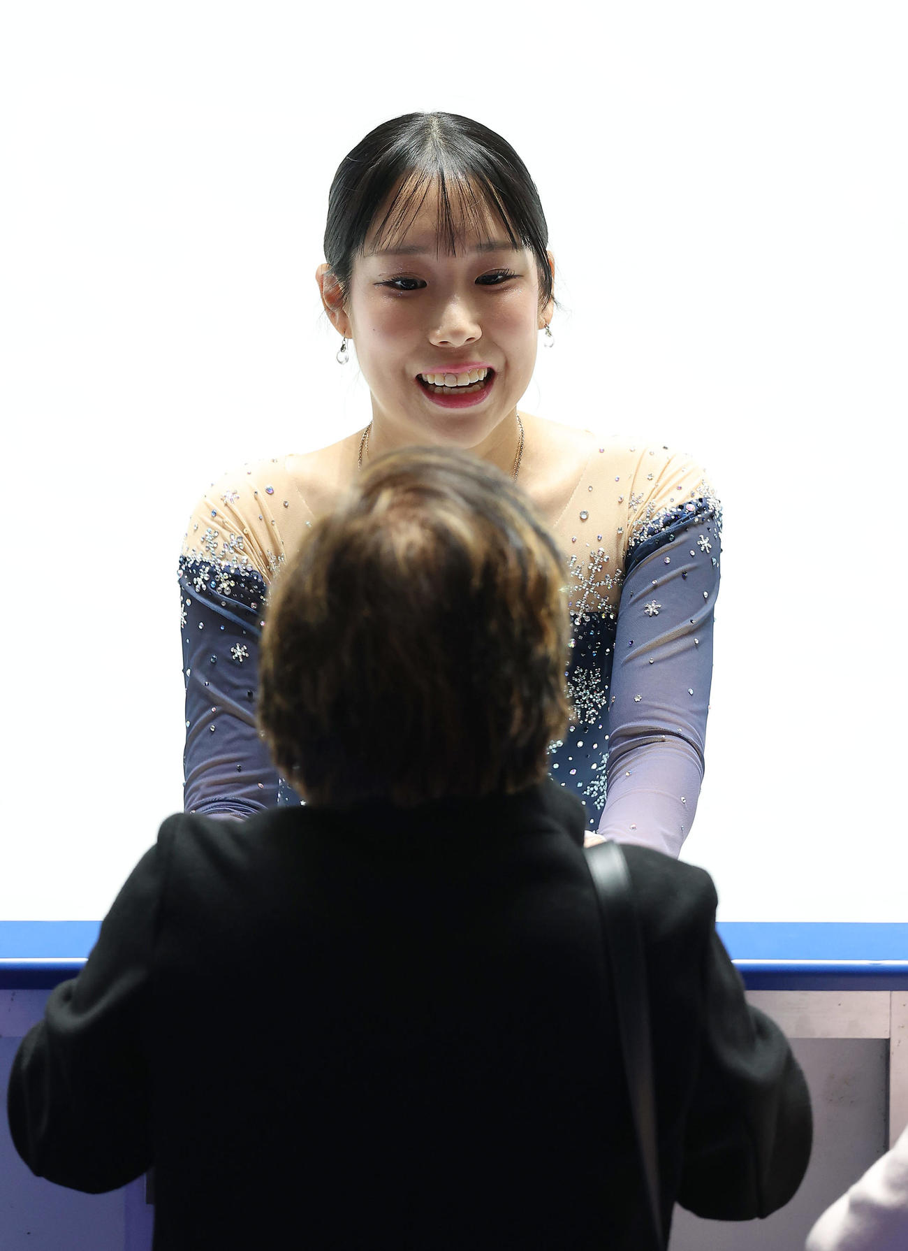中野コーチ（手前）と言葉を交わし、笑顔で女子SPの演技に臨む三原（撮影・前田充）