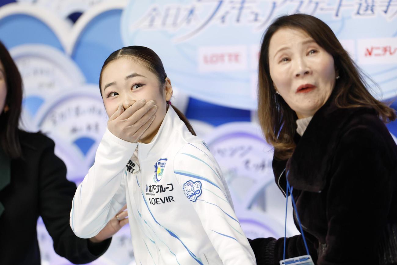 女子SPの得点を確認し、驚く島田麻央。右は浜田美栄コーチ（共同）