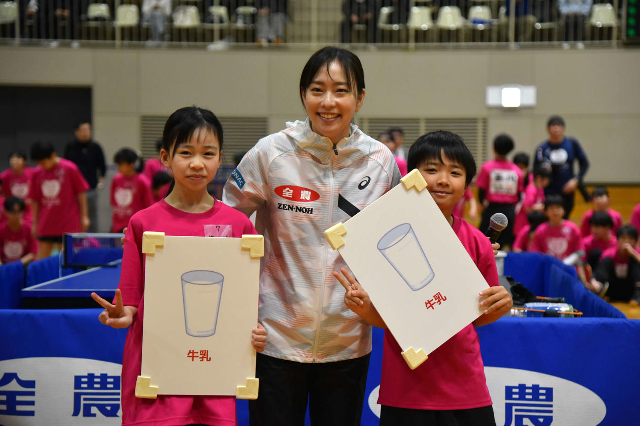 食材かるたゲームで正解した子どもたちと記念撮影する石川さん
