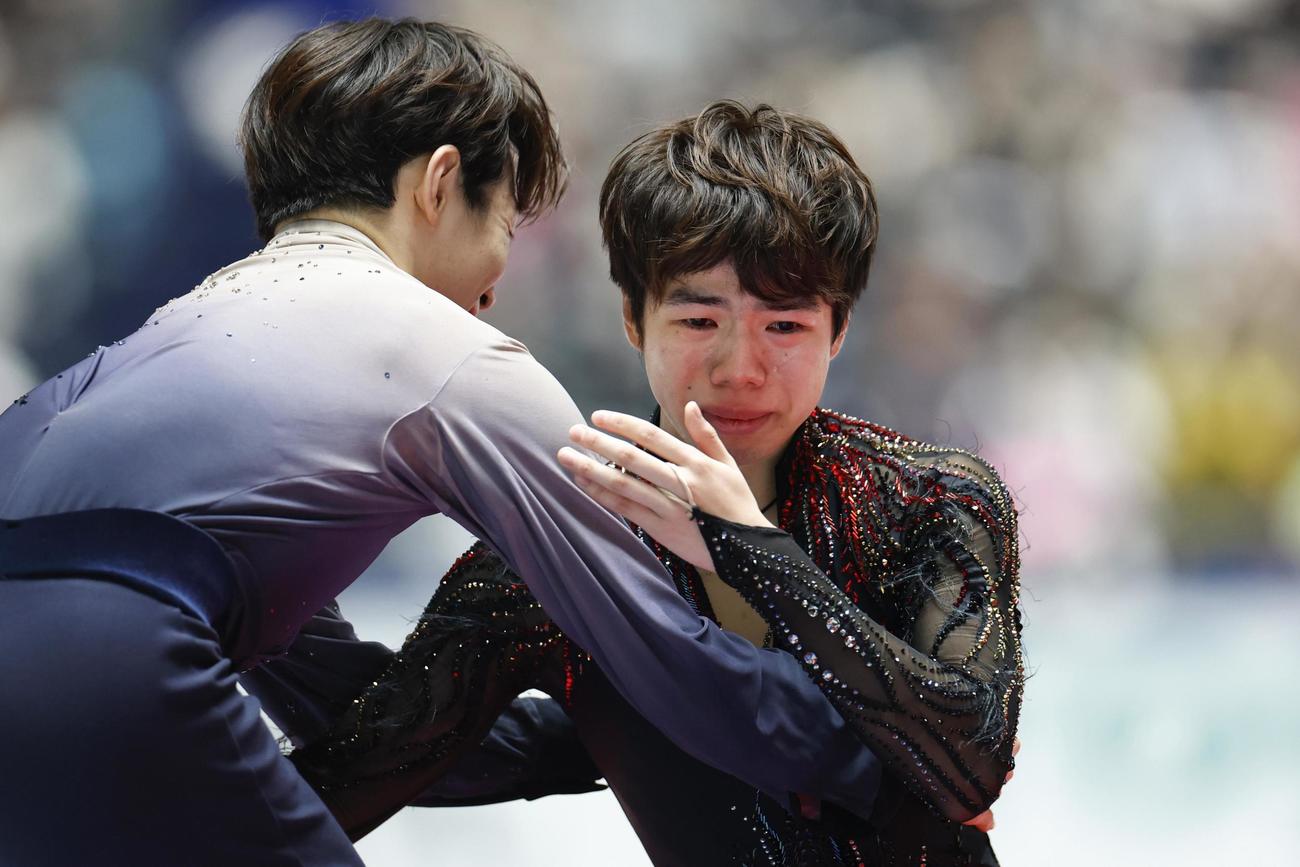 表彰式で優勝した鍵山優真（左）と涙ながらに抱き合う佐藤駿＝国立代々木競技場（共同）