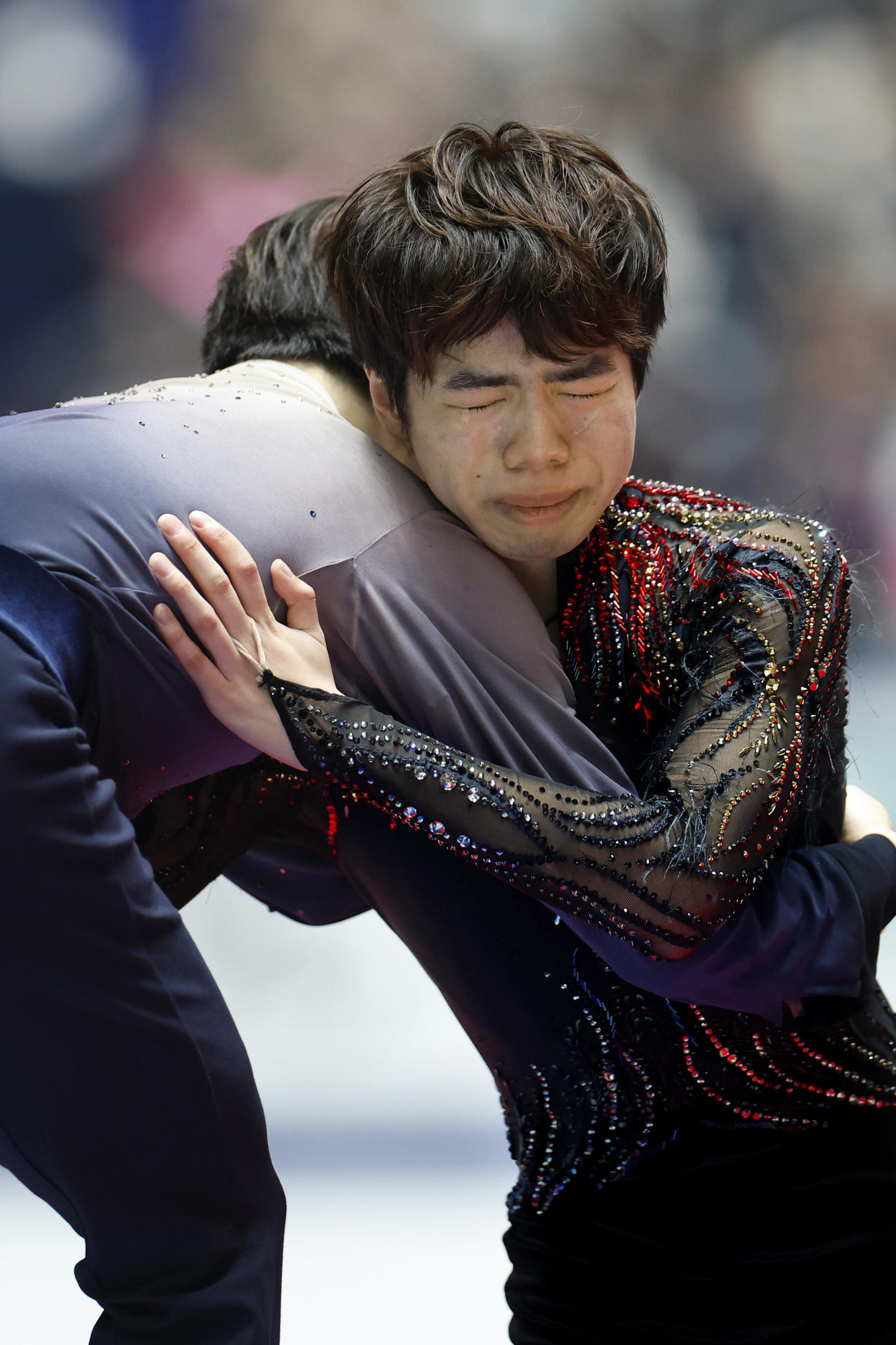 表彰式で優勝した鍵山優真（左）と涙ながらに抱き合う佐藤駿＝国立代々木競技場（共同）