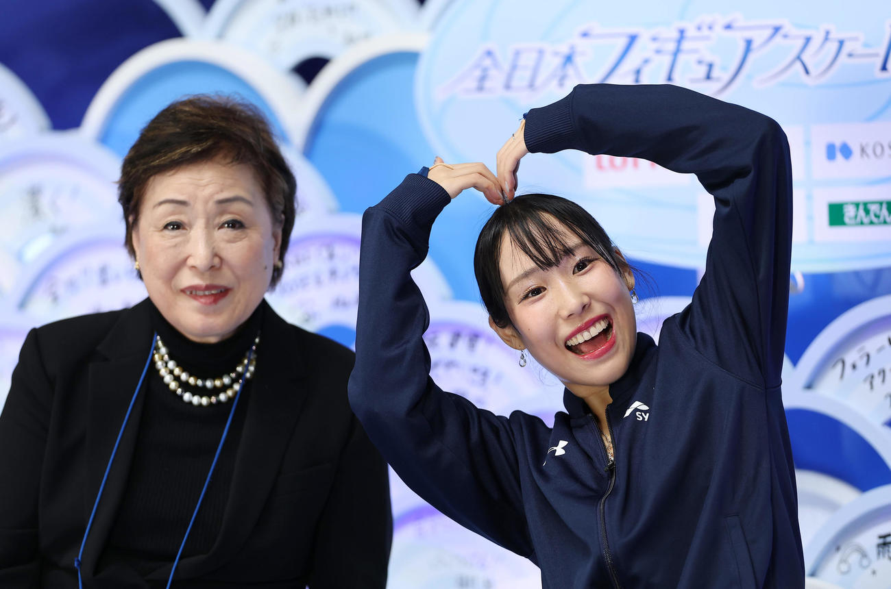 女子フリーの演技を終え、ファンに向かってポーズをとる三原。左は中野コーチ（撮影・前田充）