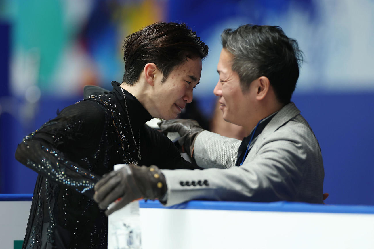 男子フリーの演技を終え平池コーチ（右）に迎えられ、涙を見せる友野（25年12月撮影）