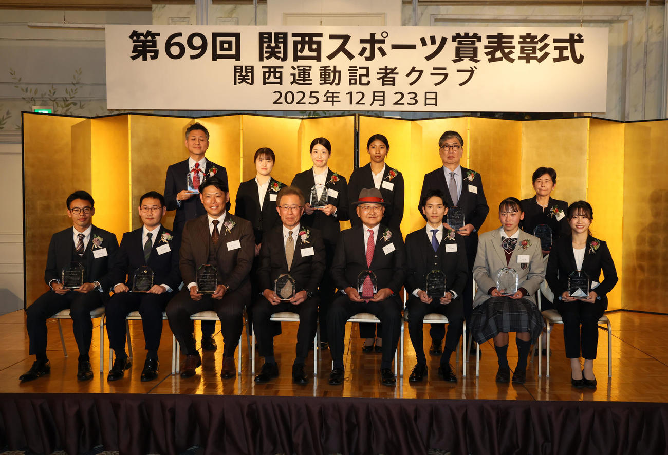 写真に納まる関西スポーツ賞の各賞受賞者。前列左から山西利和、高山勝成、原口文仁、阪神タイガースの粟井一夫球団社長、矢作芳人調教師、坂井瑠星騎手、久保凛、杉原愛子、後列左からサントリーサンバース大阪の栗原圭介GM，大阪マーヴェラスの東美奈、田中瑞稀、宮部愛芽世、釜本邦茂氏の長男・達生さん、吉田義男氏の長女・八田智子さん（撮影・加藤哉）