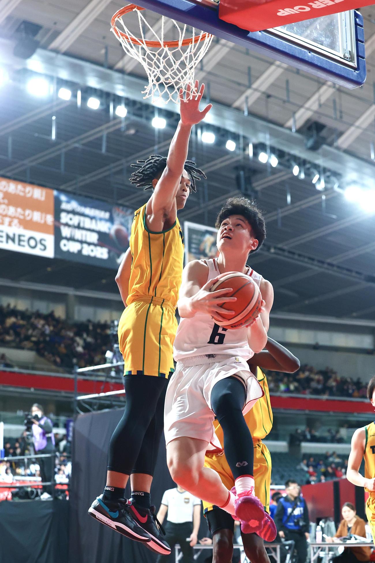 黒沢尻工対福島東稜　第3Q、福島東稜・斎藤（左）をかわし2点シュートを決める黒沢尻工・佐藤（撮影・宮地輝）