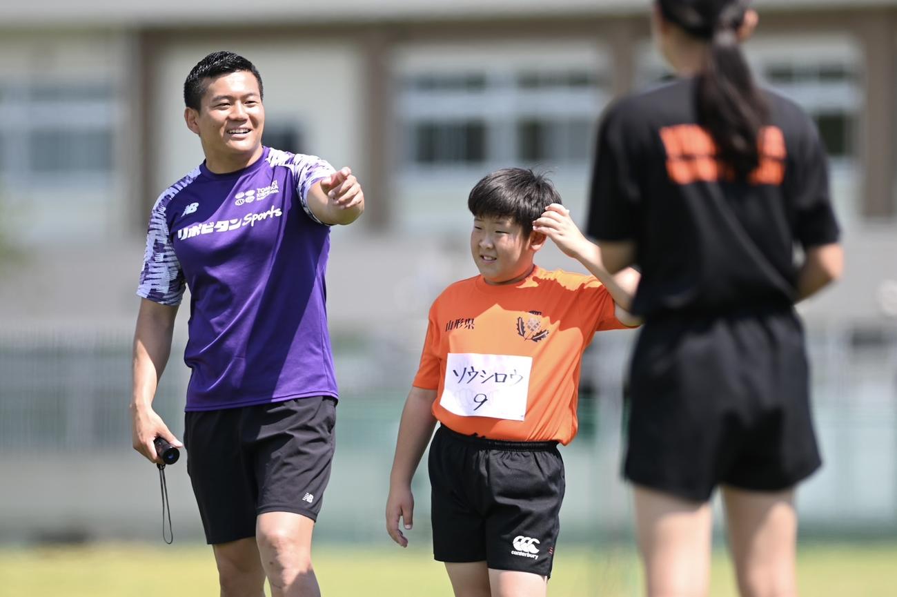 25年のラグビー教室で子どもたちを指導する岸岡智樹（左）（C）杉田恵