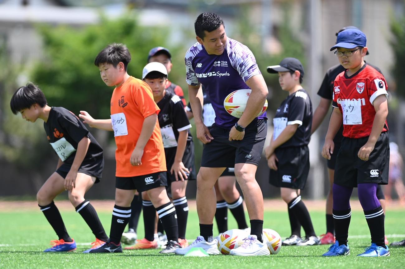 25年のラグビー教室で子どもたちを指導する岸岡智樹（前列中央）（C）杉田恵