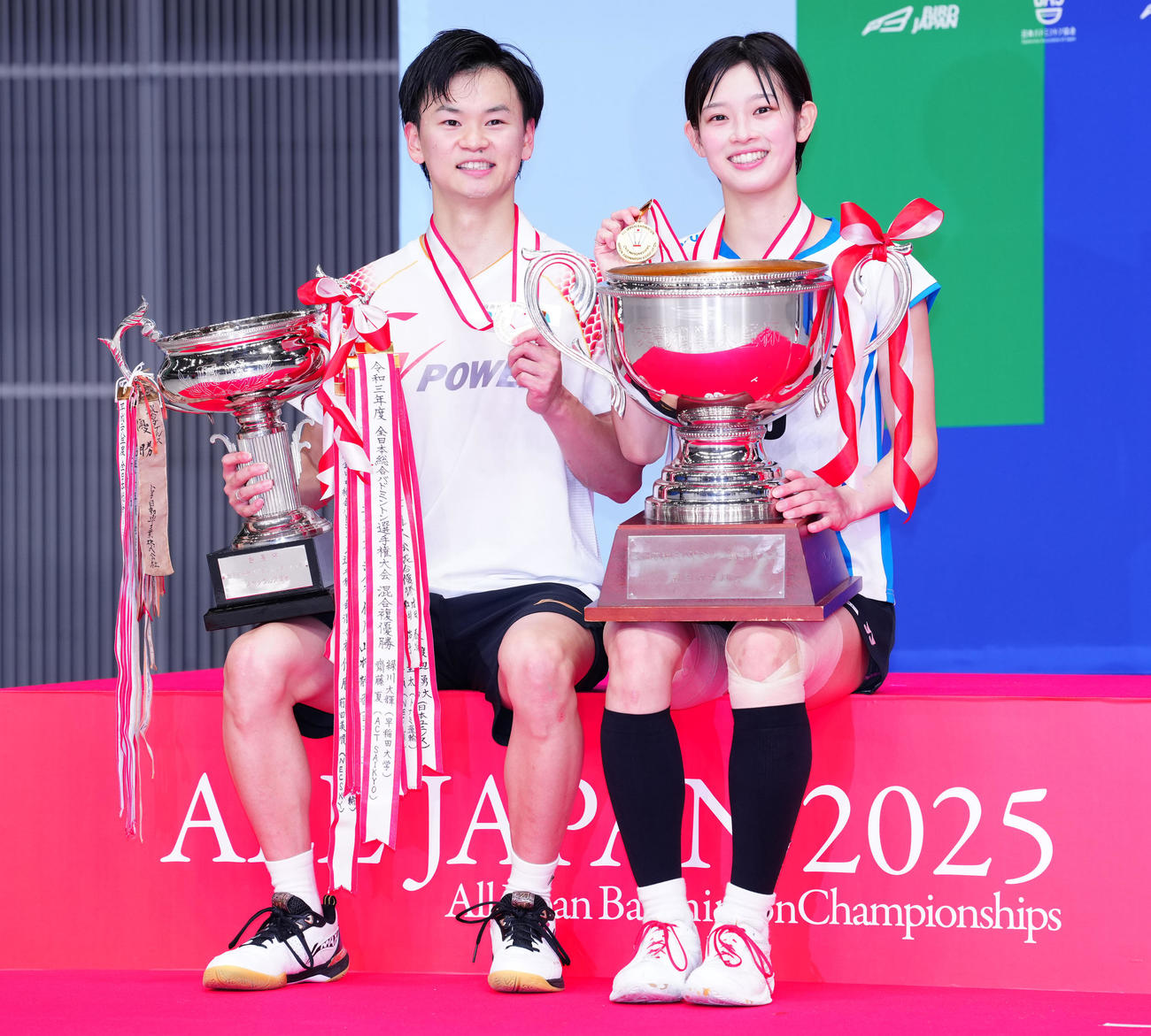 混合ダブルスで優勝し、トロフィーを手に記念撮影に納まる渡辺（左）、田口組（撮影・鈴木みどり）